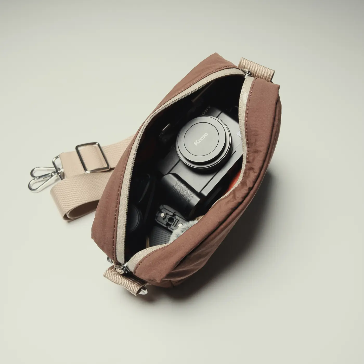 Open Urban Block Sling holding a compact camera